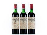 trois bouteilles de vin rouge posées l'une à côté de l'autre sur une surface blanche