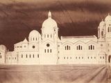 une vieille photo d'un très grand bâtiment sur lequel figure une horloge