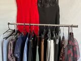 clothes hanging on a rack in front of a white wall