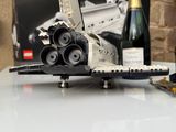 une maquette de navette spatiale posée sur une table, à côté d'une bouteille de vin
