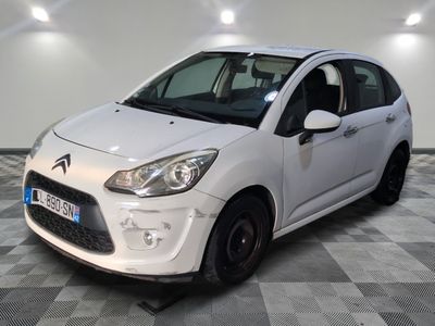 la petite voiture blanche est garée sur un sol en damier