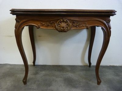 une table en bois avec un plateau sculpté et un tiroir en dessous