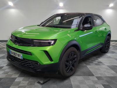 un SUV vert garé sur un sol en damier dans un garage