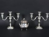 three silver plated candelabs and a silver plated candelab