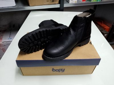 une boîte sur laquelle est posée une paire de bottes noires