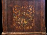 une vieille armoire en bois ornée d'un motif floral sur la façade