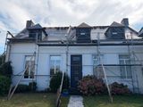 un échafaudage sur le toit d'une maison, entouré d'échafaudages
