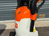 un ventilateur électrique orange et blanc posé au milieu d'un parking
