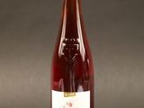 La bouteille de vin est posée sur la table, sur un fond noir.