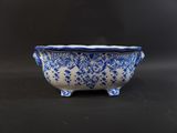 an old blue and white bowl sitting on top of a table