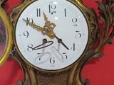 two clocks on the wall next to a mirror on the wall