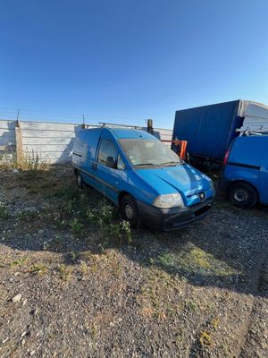 a blue van that is parked next to a blue truck