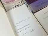 two books on a table with a pen and paper