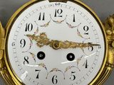 a gold clock that is hanging on the wall