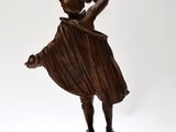 bronze statue of a woman holding a baseball bat on a marble base