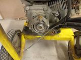 a small engine on a yellow cart in a garage