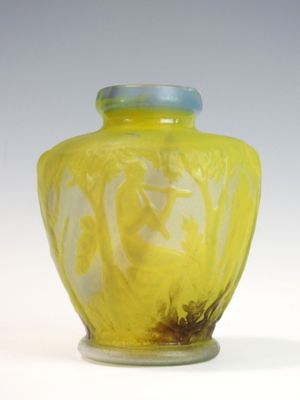 a yellow vase with a blue lid sitting on a white surface