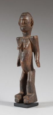 une statue en bois représentant un homme avec un sac sur le dos