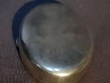 a silver pocket watch sitting on top of a table