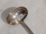 une cuillère en argent avec une étiquette, posée sur une table