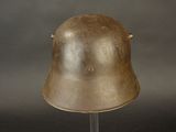 a metal helmet on a stand on a gray background