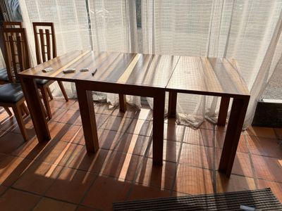 a wooden table and two chairs on a tiled floor