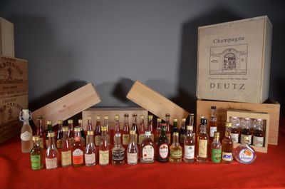 plusieurs bouteilles d'alcool posées sur une table à côté d'une caisse en bois