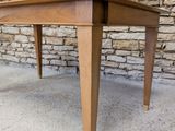 an image of a wooden table sitting in front of a brick wall