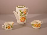 trois tasses et une théière posées sur une table