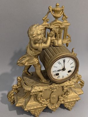a gold clock with a statue on top of it