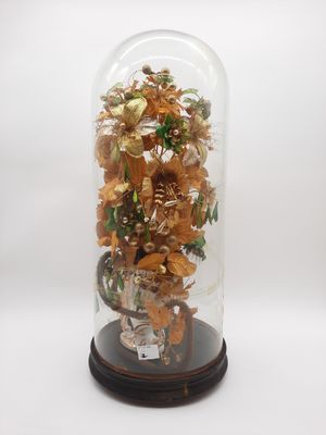 une cloche en verre contenant un assortiment d'objets en or et en argent