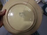a person holding a plate with a writing on it