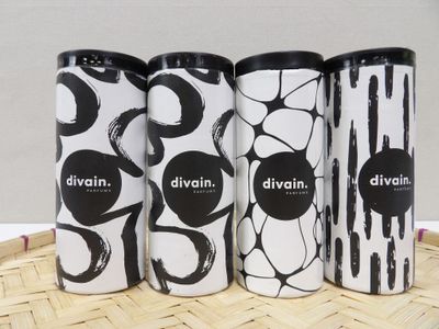 three cans of divinn are lined up on a bamboo tray