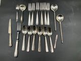 un grand nombre de cuillères et de fourchettes disposées sur une table