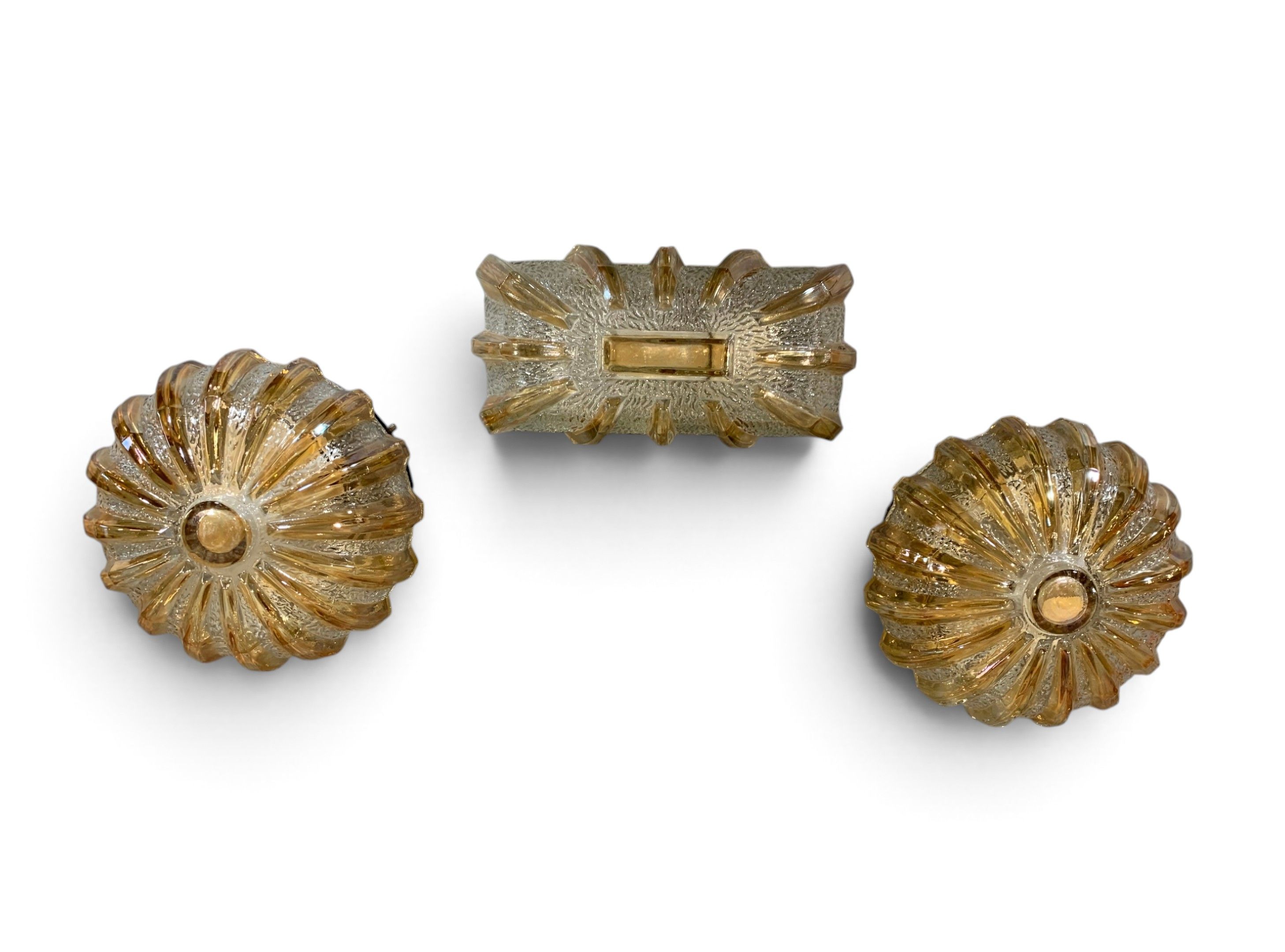 Suite de trois luminaires en verre moulé et doré.