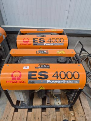 three electric generators sitting on top of a pallet in a warehouse