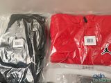 a red shirt and a black t - shirt in a plastic bag