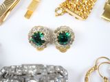 a lot of gold and green jewelry on a white surface