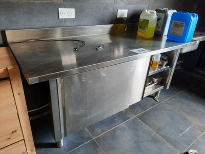 a stainless steel sink in the middle of a kitchen