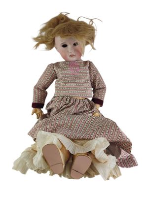 une image représentant une poupée assise sur une pile de vêtements