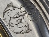 a close up of a silver plate with a design on it