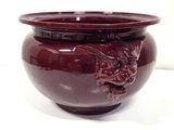 a red vase with a dragon on it on a white surface