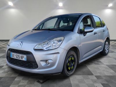 la petite voiture argentée est garée sur un sol en damier