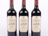 trois bouteilles de vin rouge posées l'une à côté de l'autre sur une surface blanche