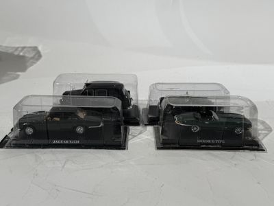 deux camions miniatures noirs posés sur une surface blanche