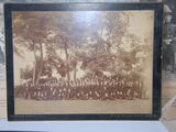 an old photo of a group of people standing in front of a tree