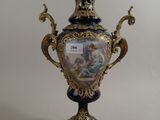 un vase noir et doré sur lequel est représentée une femme