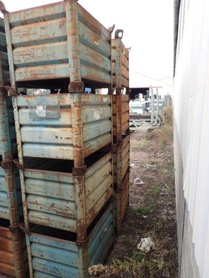 une pile de caisses posée dans une cour, à côté d'un bâtiment