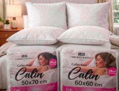 deux oreillers posés sur un lit dans une chambre, près d'une fenêtre