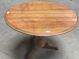a wooden table with a round top and a wooden base
